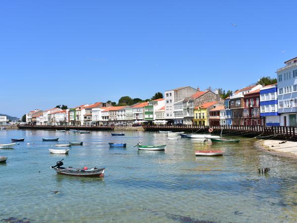 Mugardos - Kleines Küstendorf mit Fischerbooten und klarem Himmel