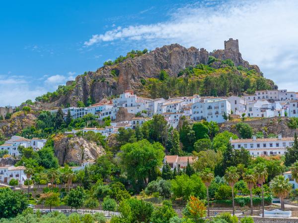 Zahara de la Sierra - malerisches "weißes Dorf" (Pueblo Blanco) in Andalusien, Spanien, das für seine atemberaubende Lage an einem Berghang und die Überreste einer maurischen Burg bekannt ist